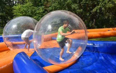 Świetne pomysły na team building: ludzie w dmuchanych kulach na wodzie, śmiech i zabawa gwarantowane!