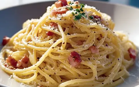 En krämig portion pasta carbonara med guanciale, parmesan och svartpeppar.