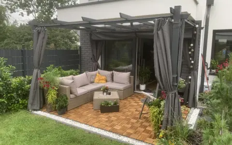 Nowoczesna pergola w ogrodzie z wygodnym narożnikiem i stolikiem. Idealne miejsce na relaks i inspiracje.