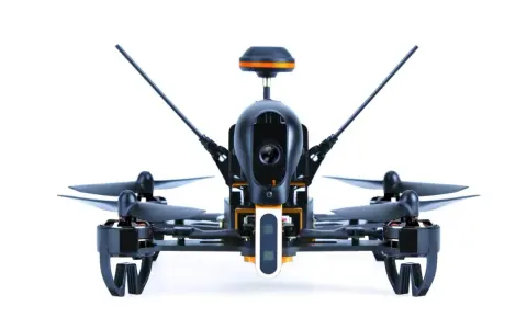 Ich sehe aus der **first person view** auf einen schwarzen Quadrocopter mit orangefarbenen Akzenten. Seine Kamera ist bereit für den Flug.