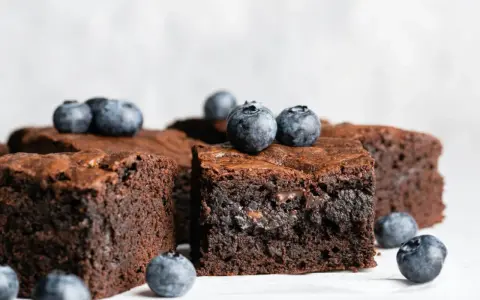 Keto brownie z mascarpone, udekorowane świeżymi borówkami. Idealne na deser bez wyrzutów sumienia.