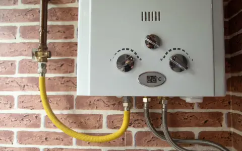 Scaldabagno bianco con tubi collegati. Il display mostra 8.8°C. Speriamo che non fischi!