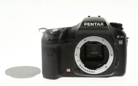 Czarny aparat Pentax K10 z widocznym mocowaniem obiektywu i osłoną. Wewnątrz widoczny jest sensor ccd.