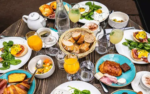 Un festin parisien : œufs Bénédicte, croissants, jus d'orange et café. Une spécialité parisienne pour un brunch gourmand.