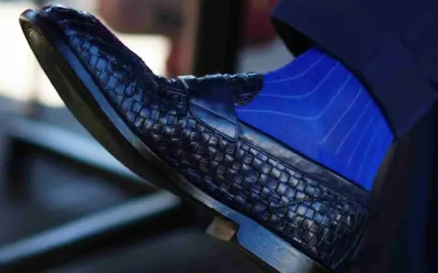 Scarpe blu intrecciate con calzini blu a righe: un abbinamento elegante per un look sofisticato.