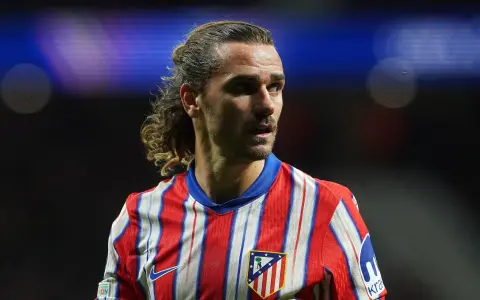 Grizman w koszulce Atletico Madryt, z charakterystyczną fryzurą, skupiony na boisku.