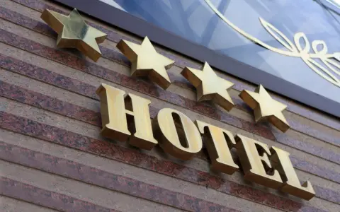 Złote gwiazdki nad napisem HOTEL. To one decydują, kto nadaje gwiazdki hotelom, wskazując na jego standard.