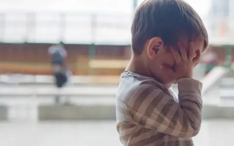 Niño con las manos en la cara, parece abrumado. A veces, mi hijo me genera ansiedad.