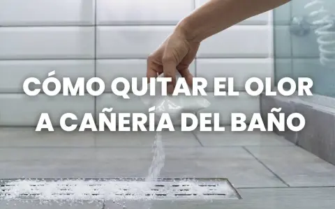 Mano esparciendo gránulos blancos en un desagüe de ducha para eliminar el olor a tuberías del baño.