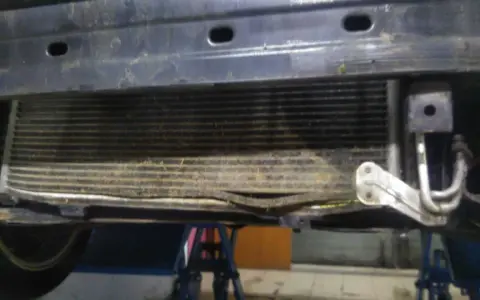 Uszkodzony skraplacz klimatyzacji objawy: zgięte żeberka, widoczne uszkodzenia mechaniczne.