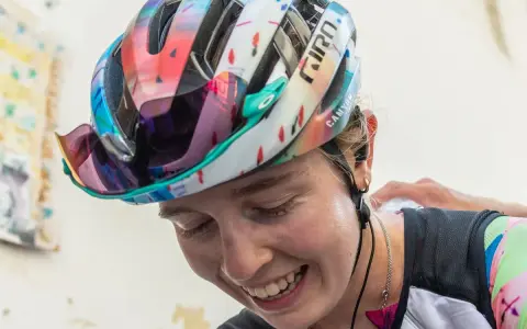 Lachende Antonia Niedermaier mit buntem Helm und Brille, bereit für das nächste Rennen.