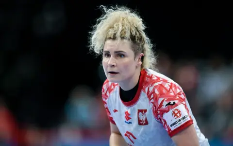 Sylwia Matuszczyk, zawodniczka w białej koszulce z czerwonymi wzorami, skupiona na boisku.