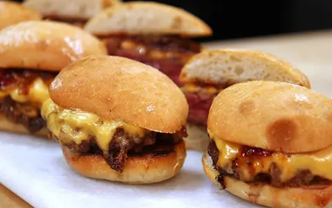 Små, saftiga hamburgare med smält ost och karamelliserad lök. Ett perfekt hamburgare recept för en festlig tillställning.