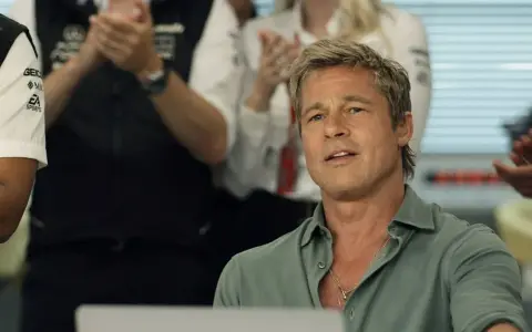 Brad Pitt en la f1 pelicula, con un equipo de boxeo detrás.