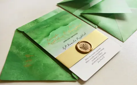Zielone zaproszenia z akwarelowymi wzorami i złotym lakowym stemplem. Czy warto inwestować w personalizowaną papeterię rzemieślniczą z lakiem? Tak!