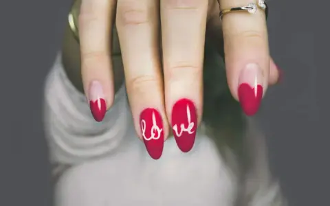 Unghie gel rosse con cuore e scritta "love". Perfetti disegni unghie gel facili per San Valentino.