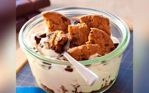 Un délice crémeux avec des morceaux de tiramisu cookies et des pépites de chocolat, servi dans un bocal en verre.