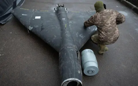 Ein Soldat inspiziert eine Drohne in Rumänien. Daneben liegt eine Munitionshülse.