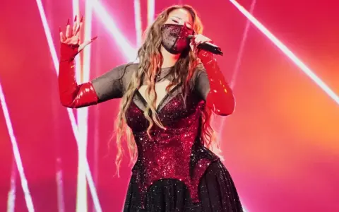 Artist med mask och röda handskar sjunger på scen. Kanske en försmak av Eurovision 2026 tid?