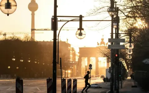 A lone runner passes the Brandenburg Gate at sunrise. This iconic Berlin landmark is a must-see, no matter how many days in Berlin you have.