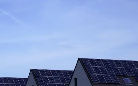Dachy domów pokryte panelami fotowoltaicznymi. Stabilizator napięcia fotowoltaika zapewnia optymalną pracę instalacji.
