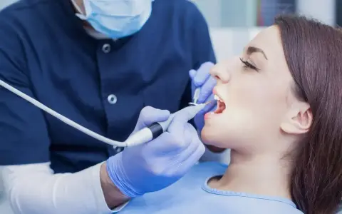 Dentysta wykonuje zabieg. Zastanawiasz się, ile kosztuje znieczulenie u dentysty? To zależy od rodzaju i gabinetu.