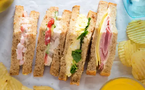Cuatro bocadillos saludables para el cole: de gambas, pollo y tomate, huevo y espinacas, y jamón y queso.