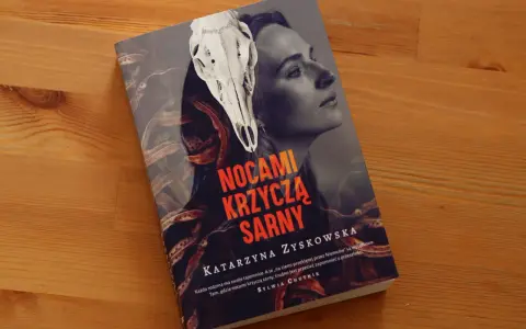 Okładka książki "Nocami krzyczą sarny" z czaszką sarny i twarzą kobiety. Tajemnicza historia o rodzinnych sekretach.