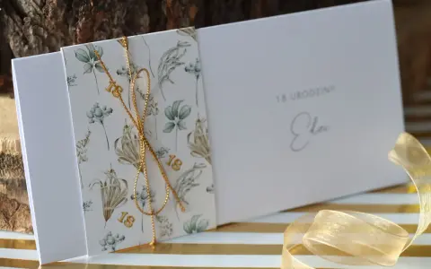 Eleganckie zaproszenia na 18 urodziny z motywem roślinnym i złotym sznurkiem. Idealne, by pokazać, jak spersonalizować zaproszenia na osiemnastkę diy pomysły i materiały.