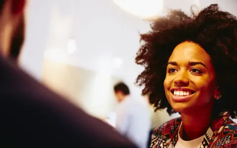 Donna sorridente in un colloquio, pensando a che lavoro fare a 40 anni senza esperienza.