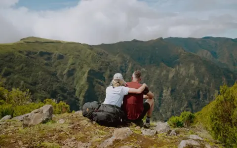 Ein Paar genießt die Aussicht auf die Berge Madeiras. Ein perfekter Moment beim Wandern, um die Sehenswürdigkeiten der Insel zu erleben.