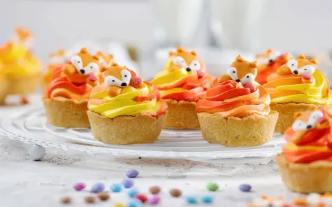 Niedliche Fuchstörtchen mit orange-gelber Creme, perfekt als Geburtstagskuchen für Kinder.