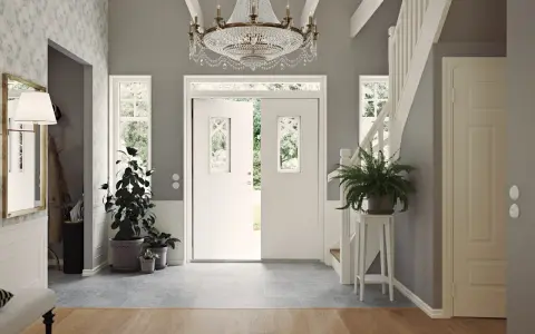 Välkomnande hall med dubbeldörrar, kristallkrona och trappa. Gröna växter ger liv åt det inredda utrymmet.