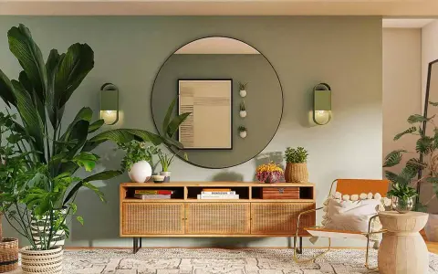 Ingresso accogliente con piante rigogliose, mobile in legno con rattan e un'opera d'arte astratta. La parete verde crea una **tabella colori caldi** rilassante.