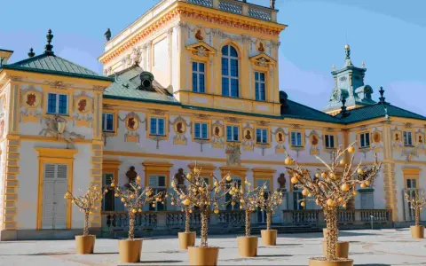 Pałac w Wilanowie, jeden z najpiękniejszych muzeów w Polsce, z barokową fasadą i ozdobnymi drzewkami w donicach.