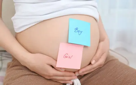 Brzuszek ciężarnej z karteczkami "Boy" i "Girl". Czy płeć dziecka może się zmienić?