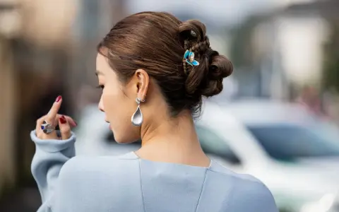 Peinado recogido con trenzas y moños, adornado con un pasador de mariposa. Un look de recogidos sencillos y elegantes.