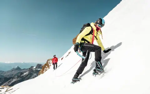Wspinaczka na lodowiec w Austrii, Grossglockner. Dwie osoby wspinają się po ośnieżonym zboczu.