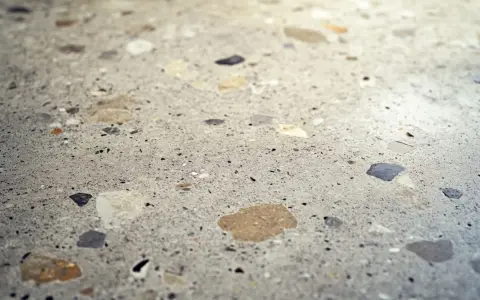 Detalle de suelo de terrazo con fragmentos de piedra. Aprende cómo limpiar suelo de terrazo para mantenerlo impecable.
