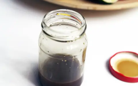 Słoik z domowym sosem balsamicznym i otwartą czerwoną zakrętką.