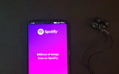 Telefon z aplikacją Spotify i słuchawkami. Idealne do słuchania wzruszających piosenek o przyjaźni.