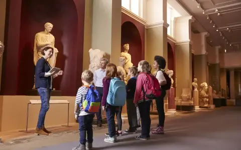 Un grupo de niños disfruta de las exposiciones en un museo de Madrid, aprendiendo sobre arte e historia con su guía.