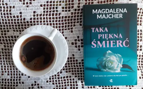 Kawa i książka Magdaleny Majcher "Taka piękna śmierć" na białej serwetce.