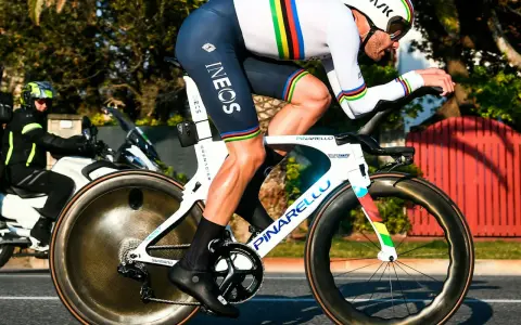 Filippo Ganna im Zeitfahr-Trikot mit Regenbogenstreifen auf seinem Pinarello-Rad, bereit für Höchstleistungen.