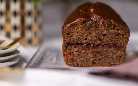 Saftiger buchweizen kuchen mit Schokoladenglasur und einer Füllung aus roter Marmelade.