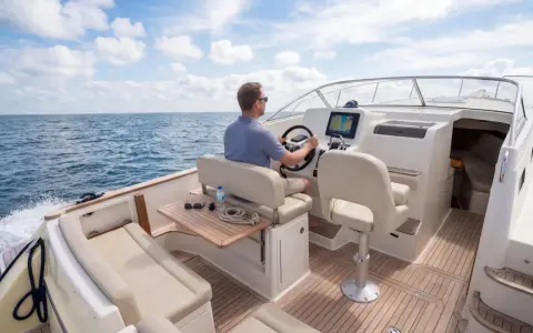 Un homme pilote un bateau sur la mer, le tableau de bord affiche le numéro MMSI.