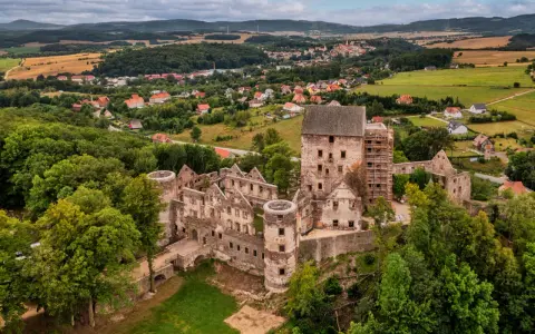 Ruiny zamku w Świnach otoczone zielenią, z widokiem na okoliczną wieś i wzgórza.