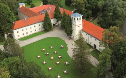 Trzebieszowice zamek na skale, otoczony zielenią, z dziedzińcem i ogródkiem kawowym.