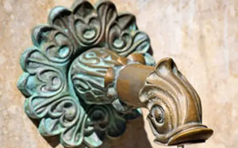 Robinet en laiton orné, avec des traces de vert-de-gris.