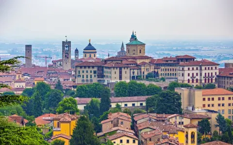 Panorama Bergamo, gdzie zwiedzić warto zabytkowe wieże i kopuły. Miasto zachwyca architekturą i zielenią.